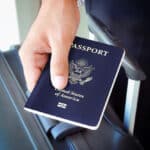 Close-up of a hand holding a U.S. passport, symbolizing expatriation and the potential need to file Form 8854.