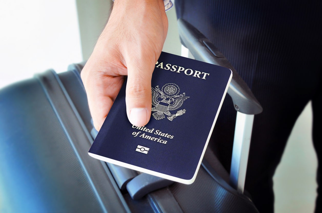 Close-up of a hand holding a U.S. passport, symbolizing expatriation and the potential need to file Form 8854.