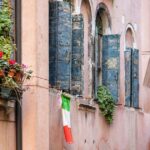 Italian flag draped outside a traditional Italian home
