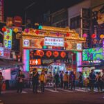 Image of the Taiwan Night Market at night, with neon lights and full of people