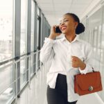 US expat walks down the hallway speaking to her expat CPA on the phone about applying the FEIE to her earned income.