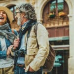 Happy older couple walking through a city street, reflecting the everyday life of people who may need an ITIN for US tax purposes.