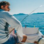 Young man fishes off a sailboat in Croatia
