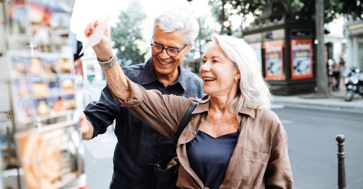 Americans retiring in France explore a local market and select postcards to send to loved ones in the US.