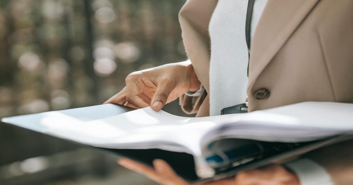 woman holding a binder with documents wondering whether to hire a tax professional