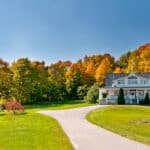 Charming house framed by autumn trees, capturing the dream many have when buying property in Canada.