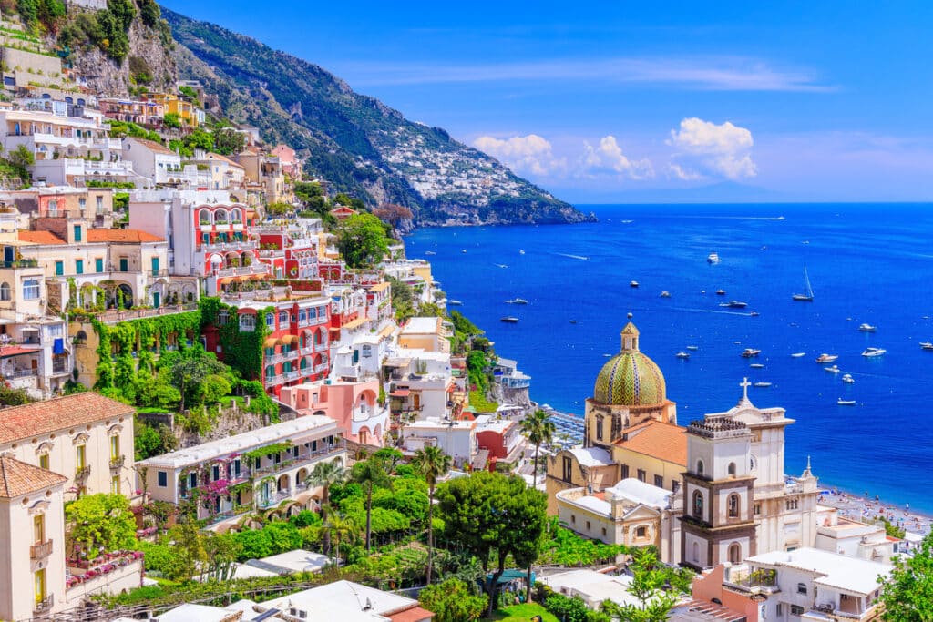 Sunset over Positano on the Amalfi Coast, capturing the romantic lifestyle enjoyed by many Americans living in Italy.